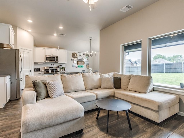 living room with plenty of natural light, dark wood-type flooring, and visible vents