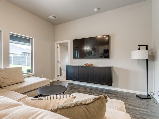 living room featuring visible vents, baseboards, and wood finished floors