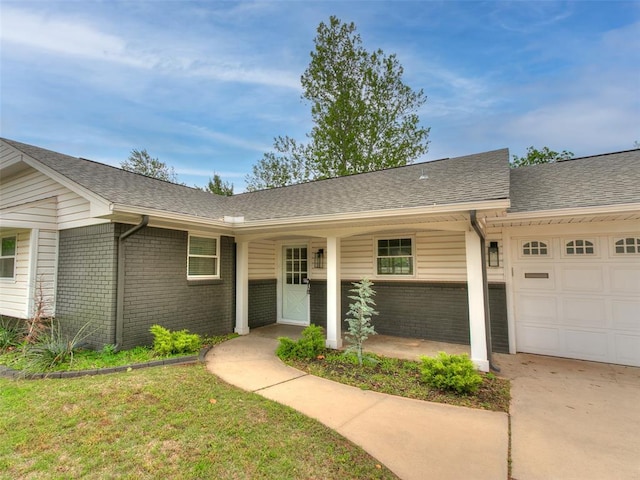 ranch-style house with a garage, concrete driveway, roof with shingles, and brick siding