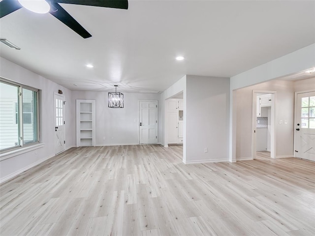 unfurnished living room with visible vents, baseboards, recessed lighting, light wood finished floors, and ceiling fan with notable chandelier