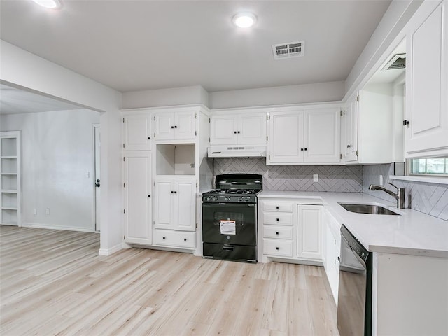 kitchen with visible vents, black gas stove, a sink, light wood finished floors, and dishwashing machine