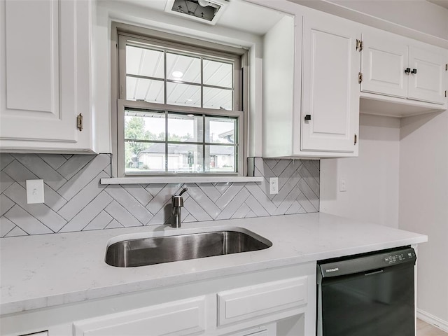 kitchen featuring white cabinets, decorative backsplash, a sink, and dishwasher