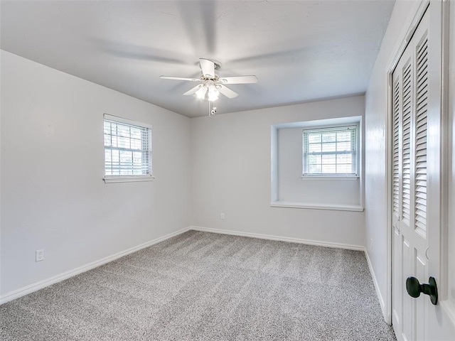 unfurnished bedroom featuring baseboards, multiple windows, and carpet flooring