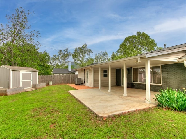 view of yard with fence, an outdoor structure, a shed, cooling unit, and a patio