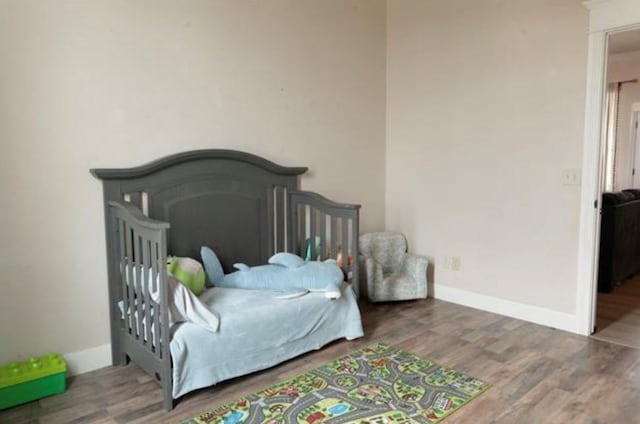 bedroom with baseboards and wood finished floors