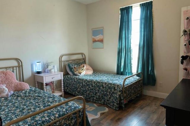 bedroom featuring baseboards and wood finished floors