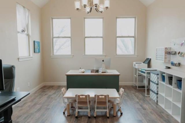 dining area featuring an inviting chandelier, baseboards, vaulted ceiling, and wood finished floors