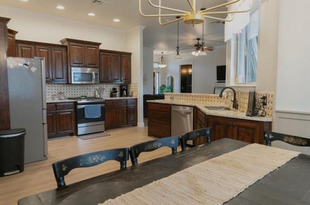 kitchen featuring a sink, appliances with stainless steel finishes, tasteful backsplash, and light countertops