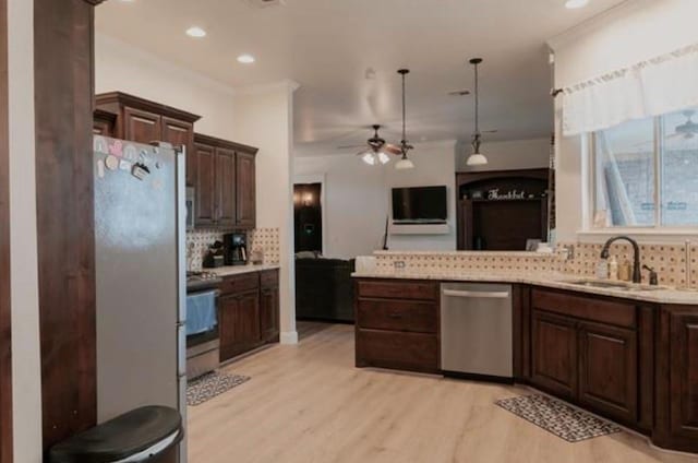 kitchen featuring dark brown cabinetry, tasteful backsplash, light wood-type flooring, a sink, and stainless steel appliances