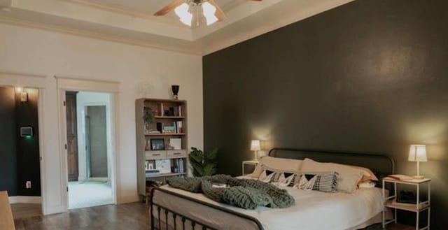 bedroom with ceiling fan, ornamental molding, and wood finished floors