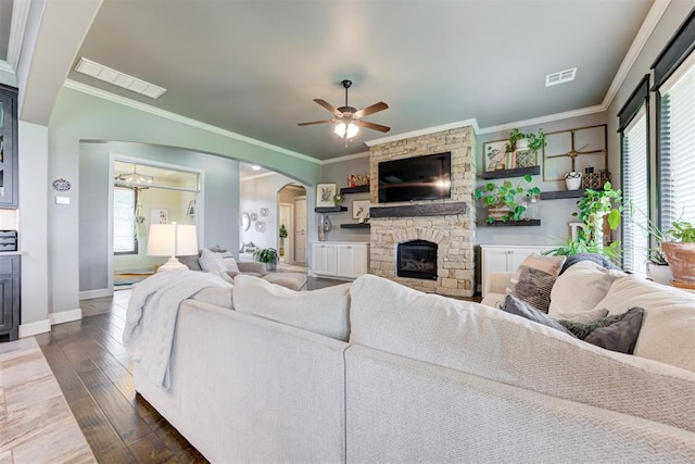 living room with crown molding, a ceiling fan, and visible vents