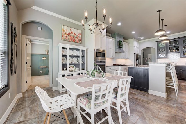 dining area with crown molding, arched walkways, a notable chandelier, and recessed lighting