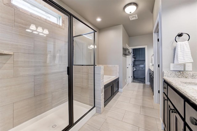 bathroom with visible vents, a garden tub, tile patterned flooring, vanity, and a stall shower