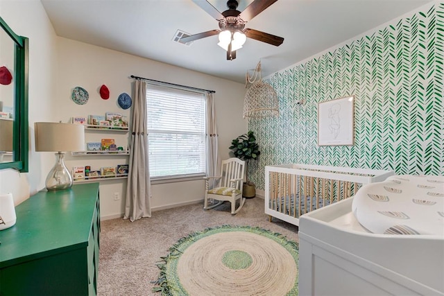 bedroom with light colored carpet, an accent wall, baseboards, wallpapered walls, and visible vents