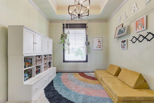 living area with crown molding, baseboards, a notable chandelier, and a raised ceiling