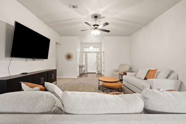 living area featuring baseboards, a ceiling fan, and visible vents