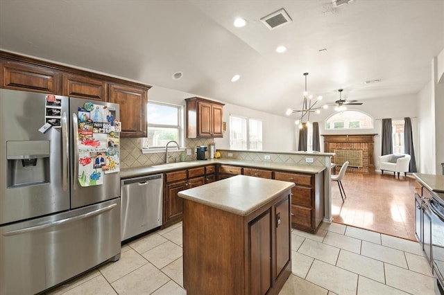 kitchen with visible vents, appliances with stainless steel finishes, tasteful backsplash, a sink, and a peninsula