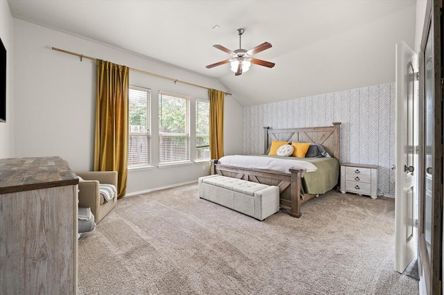 carpeted bedroom with an accent wall, a ceiling fan, lofted ceiling, and wallpapered walls