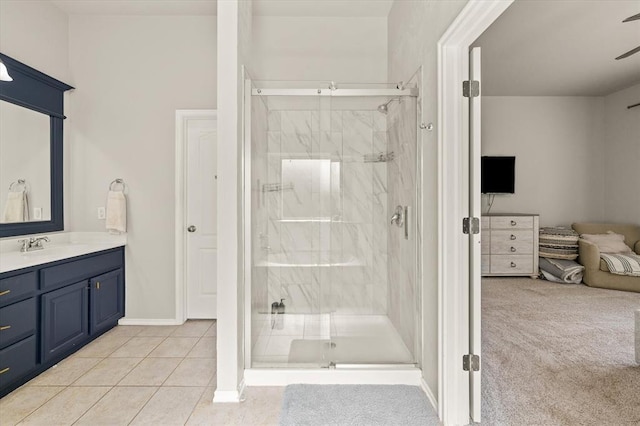 full bathroom featuring a marble finish shower, tile patterned flooring, baseboards, and vanity
