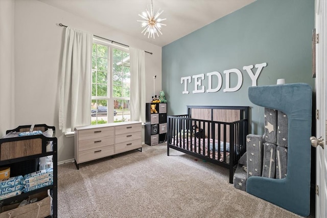 carpeted bedroom with an inviting chandelier, a nursery area, and baseboards