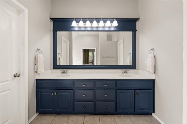 full bathroom with double vanity, tile patterned floors, and a sink