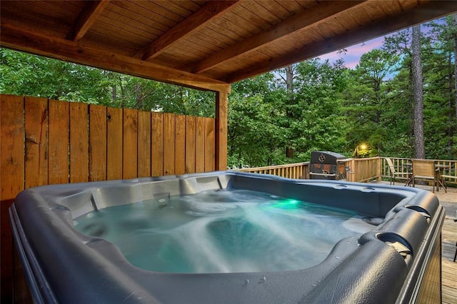 deck at dusk with a hot tub