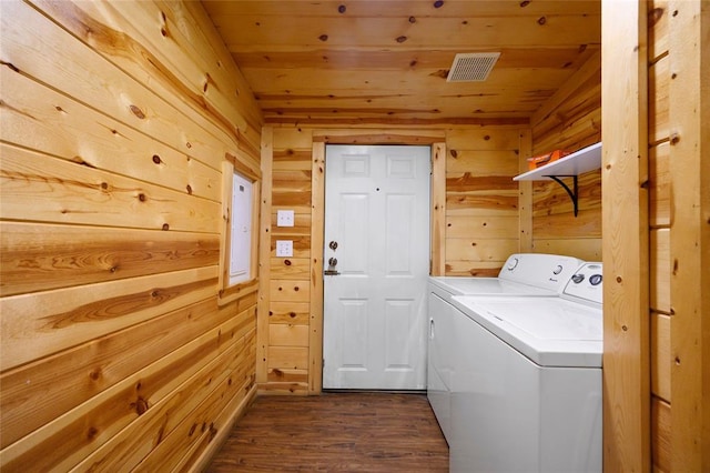 clothes washing area with wood walls, laundry area, separate washer and dryer, dark wood-style floors, and wood ceiling