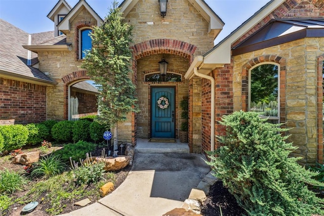 property entrance featuring stone siding and brick siding