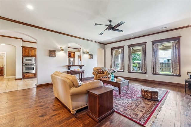 living area featuring ceiling fan, arched walkways, hardwood / wood-style floors, and visible vents