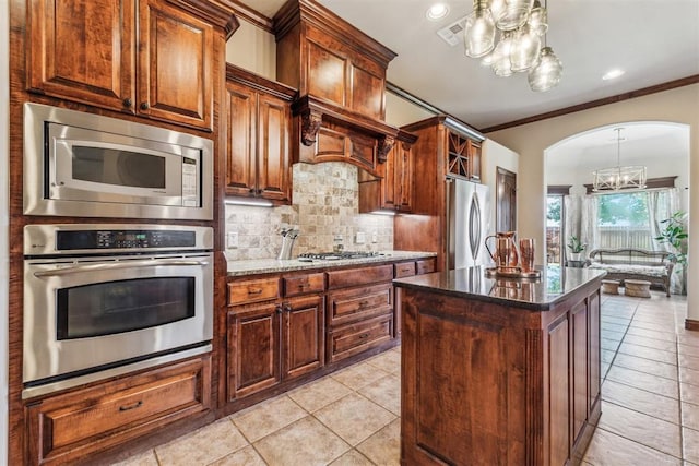 kitchen featuring an inviting chandelier, light tile patterned floors, stainless steel appliances, visible vents, and backsplash