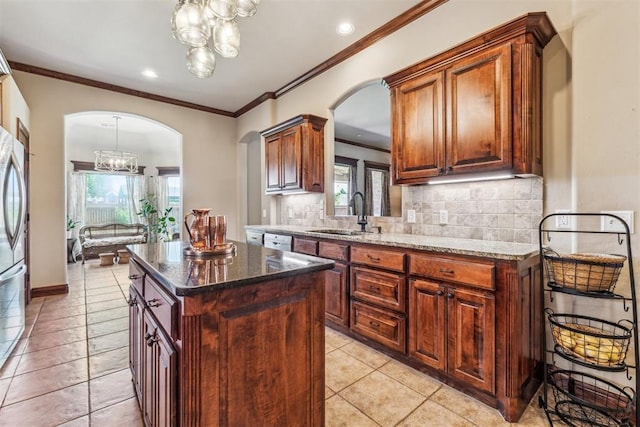 kitchen with white dishwasher, a wealth of natural light, a sink, arched walkways, and tasteful backsplash