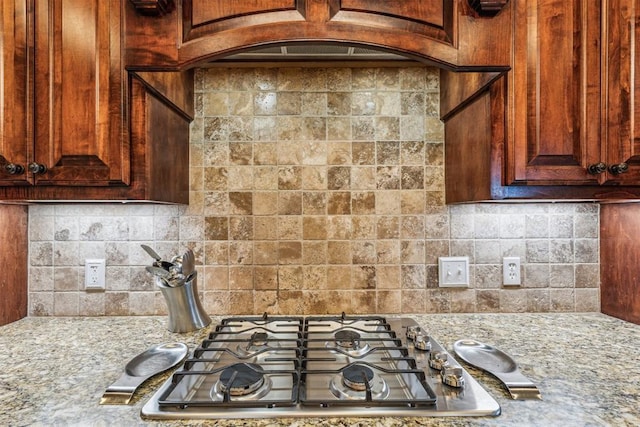 kitchen featuring light stone countertops, tasteful backsplash, and stainless steel gas cooktop