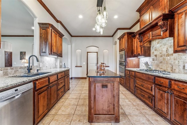 kitchen featuring a sink, arched walkways, appliances with stainless steel finishes, a kitchen island, and tasteful backsplash