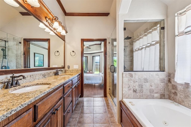 full bath featuring a stall shower, a tub with jets, double vanity, and a sink