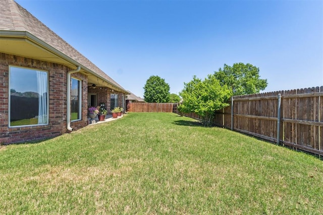 view of yard with a ceiling fan and a fenced backyard