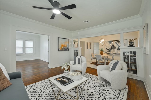 living room featuring ceiling fan, baseboards, wood finished floors, visible vents, and ornamental molding