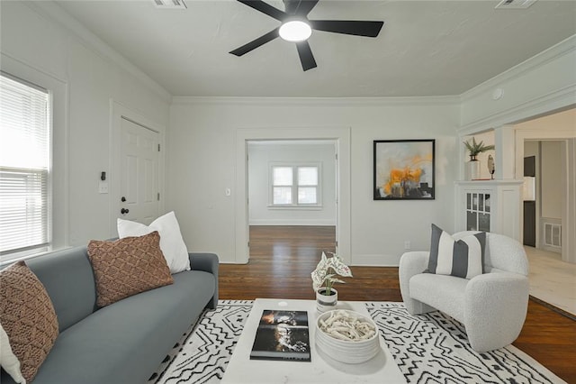 living room with ceiling fan, ornamental molding, wood finished floors, and visible vents