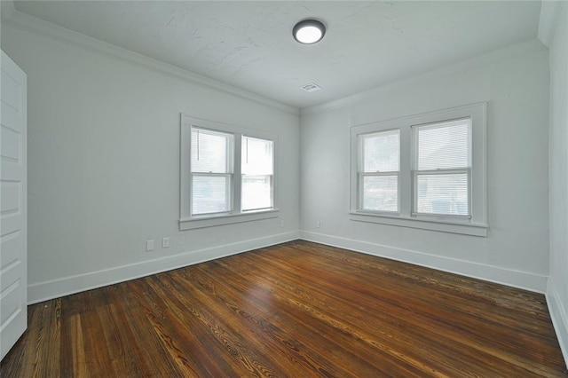empty room with baseboards, dark wood finished floors, and ornamental molding