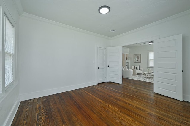 unfurnished bedroom featuring crown molding, baseboards, visible vents, and dark wood-type flooring