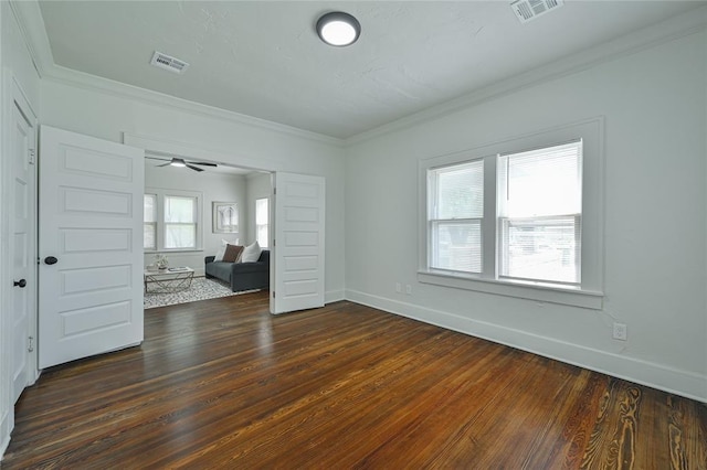 unfurnished room featuring visible vents, dark wood-style floors, and ornamental molding