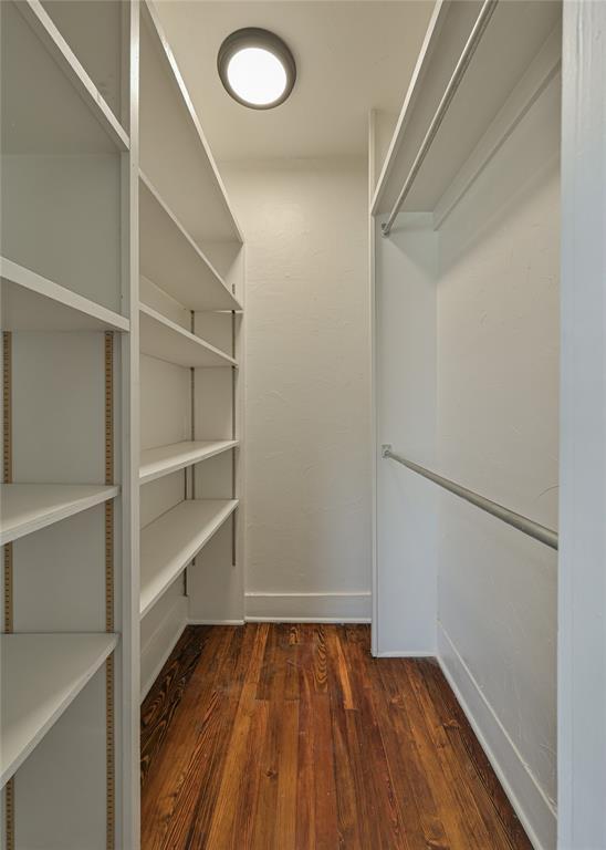 spacious closet with dark wood-style floors