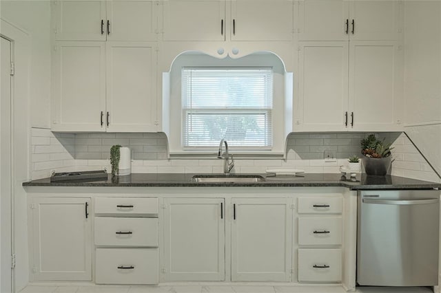 kitchen with backsplash, dishwasher, a sink, white cabinets, and dark stone countertops