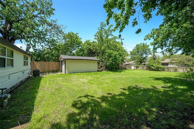 view of yard with an outdoor structure, central AC, and a fenced backyard