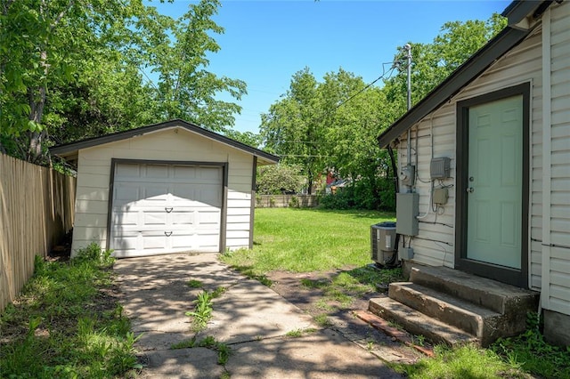 detached garage featuring fence, central air condition unit, and driveway