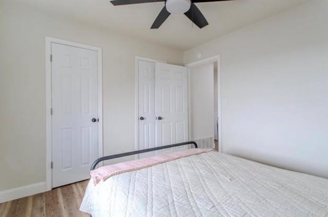 bedroom featuring baseboards, a ceiling fan, and wood finished floors