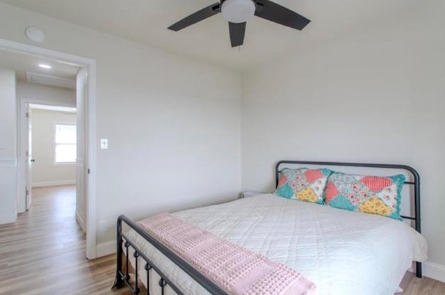 bedroom featuring baseboards, ceiling fan, and wood finished floors
