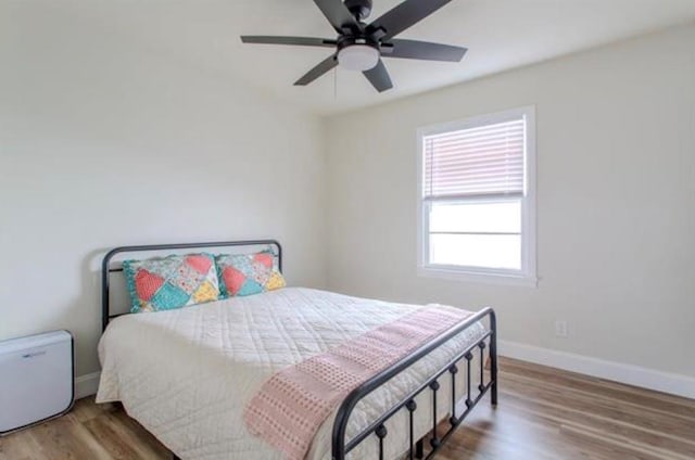 bedroom featuring baseboards, a ceiling fan, and wood finished floors