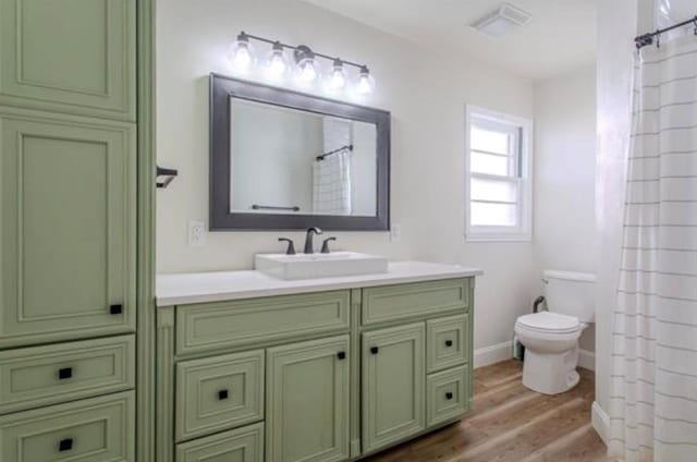 full bath featuring vanity, toilet, baseboards, wood finished floors, and visible vents