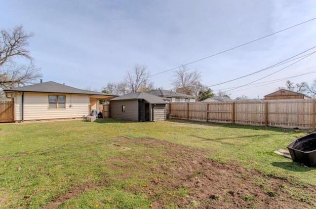 view of yard with a fenced backyard, a shed, and an outbuilding