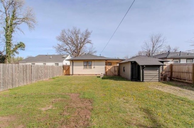 view of yard featuring a storage shed, an outdoor structure, and a fenced backyard